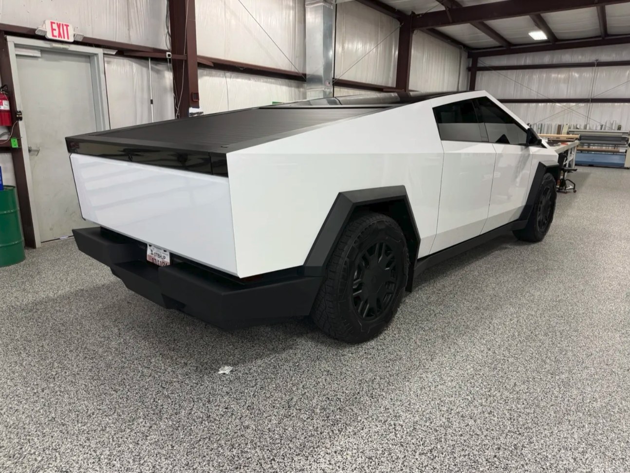2024 Tesla Cybertruck Cyberbeast wrapped in high-gloss white, rear three-quarter view in the shop